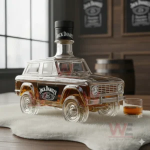 Whiskey bottle shaped like a classic SUV with amber liquid and a small tasting glass on a table!