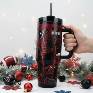 Hand holding a Houston Texans black and red tumbler with handle and straw surrounded by holiday decorations!