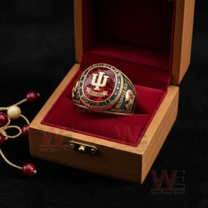 Indiana Hoosiers football ring in an open wooden box with red velvet interior featuring a red gemstone style top IU logo Hoosiers Football text and a decorative beaded accessory on a dark background!