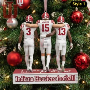 A tree ornament of three Indiana Hoosiers players in white uniforms standing arm in arm before a decorated Christmas tree!
