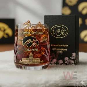 Close view of Iowa Hawkeyes anniversary whiskey glass with gold artwork and matching box.