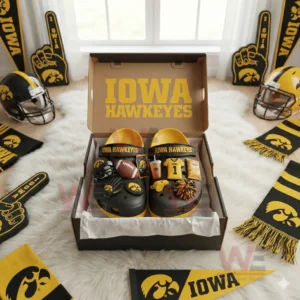 Iowa Hawkeyes themed clogs with decorative charms placed in a gift box surrounded by fan accessories!
