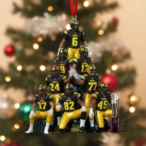 Iowa Hawkeyes players in black and yellow uniforms arranged in a pyramid ornament with a trophy beside them.