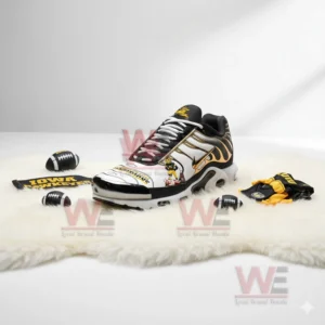 Iowa Hawkeyes sneaker on a white surface with football themed accessories around it.