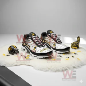 Pair of Iowa Hawkeyes sneakers with mascot graphics displayed alongside fan accessories on a white surface.