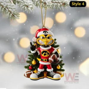 Iowa mascot in Santa outfit holding football standing before decorated tree ornament hanging from snowy branch!