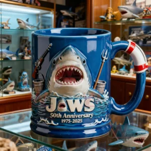 A blue Jaws fiftieth anniversary mug with a three dimensional shark displayed in a room filled with shark themed collectibles!