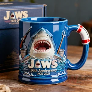 A blue Jaws fiftieth anniversary mug displayed on a wooden table with a matching themed box behind it!