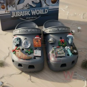 Gray Jurassic World Christmas clogs with dinosaur themed charms placed before a festive box!