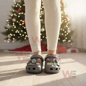 Jurassic World Christmas Crocs Clogs with Charms 4 Gray Jurassic World Christmas clogs with dinosaur charms worn in a festive room!