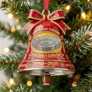 A red Arrowhead Stadium Christmas bell ornament with a gold bow and a football charm marking the years nineteen sixty to twenty twenty five!