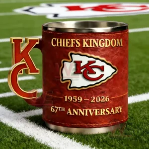 Red Kansas City Chiefs mug with KC letter handle and Chiefs Kingdom 1959 2026 67th Anniversary text sitting on a football field with yard lines.
