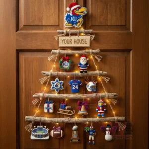 A rustic wooden branch Christmas wall tree decorated with Kansas Jayhawks ornaments and warm lights hanging on a wooden door!