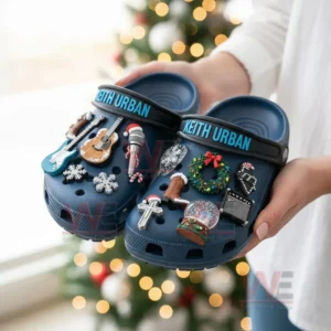 Blue Keith Urban clog shoes with music and Christmas charms held in front of a decorated tree!