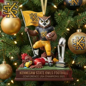A Christmas tree ornament of the Kennesaw State owl mascot holding a flag and football standing over a rival with the Conference USA trophy nearby amid gold and black decorations!