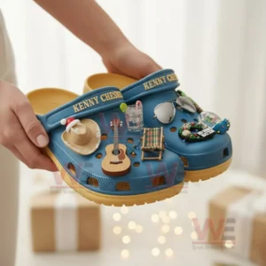 Blue Kenny Chesney clogs with beach music charms held in front of a soft holiday background!