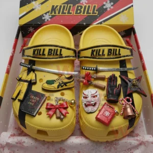 Yellow Kill Bill clogs inside a gift box covered with small detailed themed charms including weapons clothing items and festive decorations.