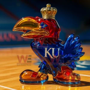 A crowned Jayhawk shaped glass bottle displayed on a basketball court.