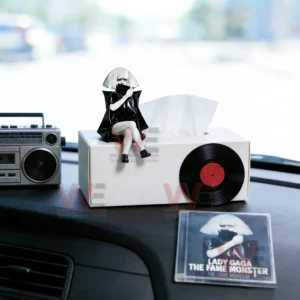 Lady Gaga themed figurine sitting on a tissue box with a boombox and The Fame Monster album case on a car dashboard!