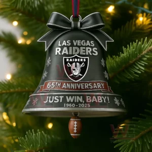 A close up of a Raiders anniversary bell ornament hanging on a lit Christmas tree.