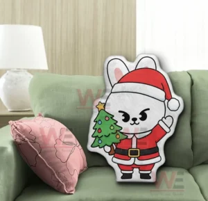 Cartoon rabbit shaped pillow in santa outfit displayed on a green sofa!