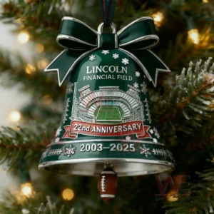 Green Christmas bell ornament with stadium artwork ribbon bow snow accents and a football charm hanging on a tree!