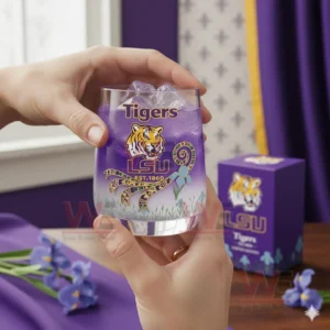 Hands holding an LSU Tigers purple glass with ice in an indoor decorative scene!