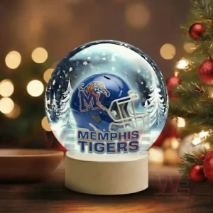 A snow globe with a blue team helmet sits beside a decorated Christmas tree with warm festive lights!