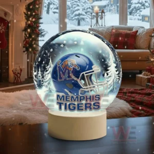 A snow globe with a blue team helmet sits in a holiday decorated living room with snow falling outside!