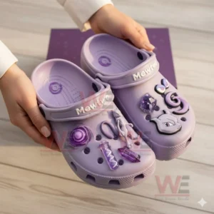 Light purple Mewtwo clogs held by hands decorated with charms shaped like crystals energy swirls and character features.