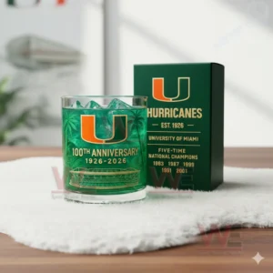 Miami Hurricanes 100th Anniversary 1926-2026 Whiskey Glass 5 Miami Hurricanes anniversary glass with green iced drink beside a dark green box in a naturally lit environment!