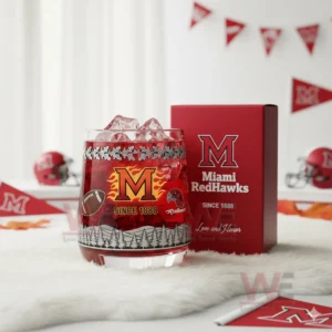 A close view of a Miami RedHawks glass with red drink and forest etching displayed beside its matching red box in a lively sports themed room!