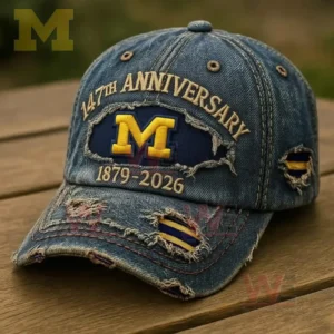 A close up view of a blue denim cap with intentional fabric distressing embroidery and a classic sports emblem placed outdoors on a wooden table!