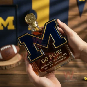 Hands holding a letter M shaped glass bottle with amber liquid and Michigan themed background!