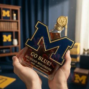 Michigan Wolverines Go Blue 146th Anniversary 1879-2025 Limited Edition Whiskey Bottle 3 Hands presenting a Michigan themed letter M glass bottle with amber tones and decorative interior!