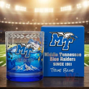 A close view of a Middle Tennessee Blue Raiders whiskey glass filled with a blue drink and ice displayed beside its blue box featuring team branding and mountain engravings!
