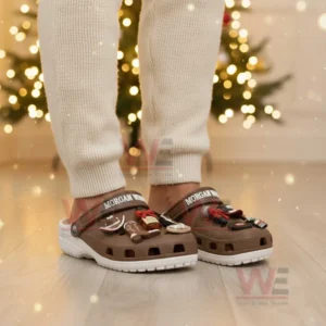Brown clogs with charms shown on feet in a cozy indoor holiday setting!