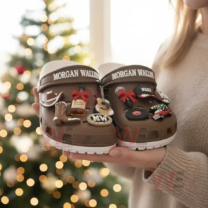 Brown clogs with multiple charms displayed in hands before a holiday background!