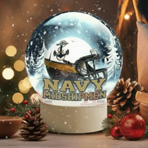 A snow globe with a white team helmet sits near pine branches ornaments and warm festive lights!