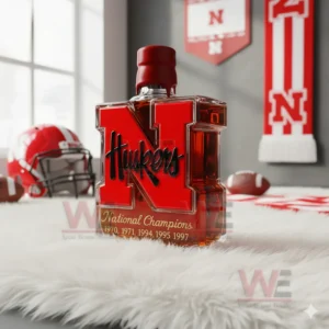 A bold red Huskers bottle positioned on a soft surface with sports themed decor in the background!
