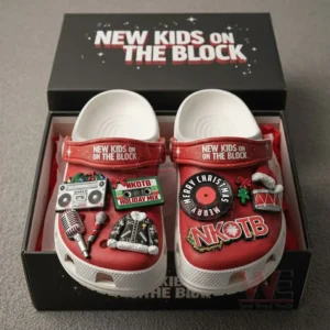 Red New Kids On The Block clogs in a gift box decorated with music and holiday themed charms including a boombox microphone jacket Christmas record and band logo.