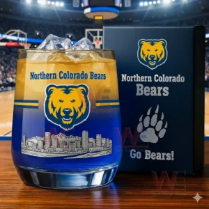 Northern Colorado Bears whiskey glass with ice and blue gold drink placed in front of a branded box inside a basketball arena!