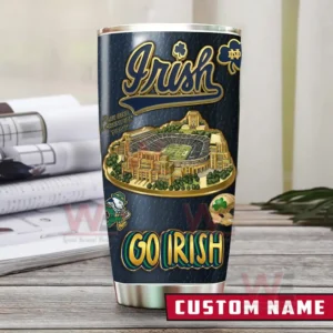 Notre Dame Fighting Irish tumbler with stadium artwork Irish script and Go Irish text displayed upright on a desk with documents in the background!