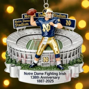 Ornament of a blue and gold uniformed football player posed before a small replica of the Notre Dame stadium with anniversary information beneath