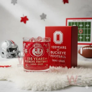 Red Ohio State Buckeyes anniversary whiskey glass with ice next to a red commemorative box on a white fur surface!