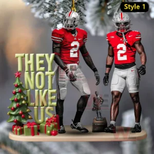 An ornament with two Ohio State players standing beside a Christmas tree and gifts with bold text included!