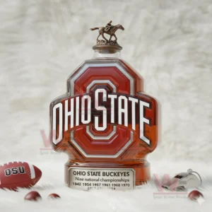Ohio State championship themed bottle with rider topper displayed on white furry surface.