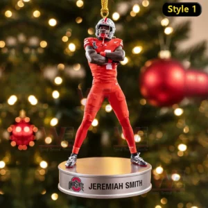 Ornament of Jeremiah Smith in full uniform standing on a base against a Christmas tree background!