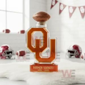 Oklahoma Sooners Boomer Sooner 1895-2025 130th Anniversary Custom Whiskey Bottle 5 A Sooners OU bottle with a football cap on white fur with helmets and footballs in a bright room.