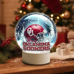 Illuminated glass sphere with Oklahoma Sooners helmet against a snowy background on a white base!